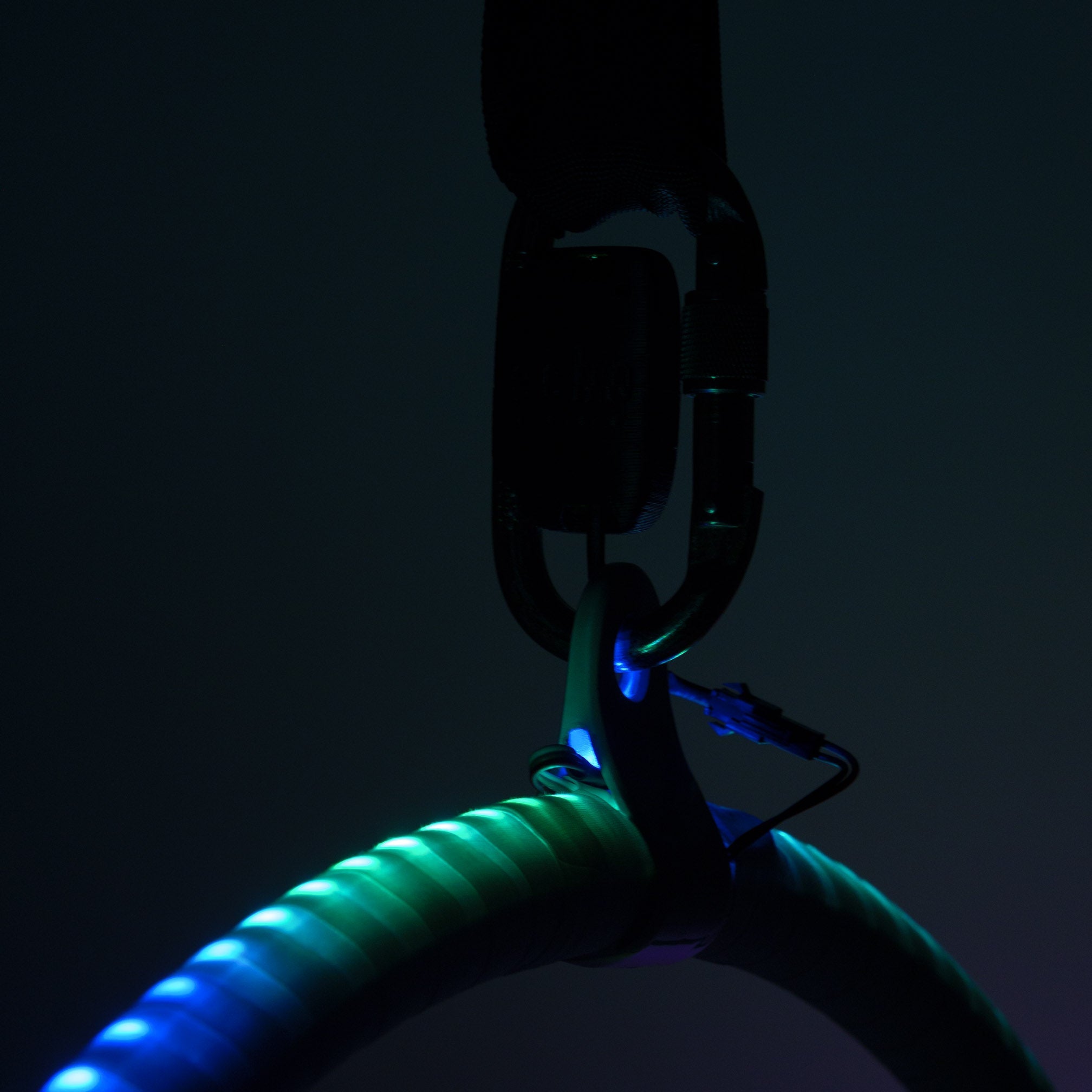 Low light, glow on hoop and silloutte of the carabiner and battery