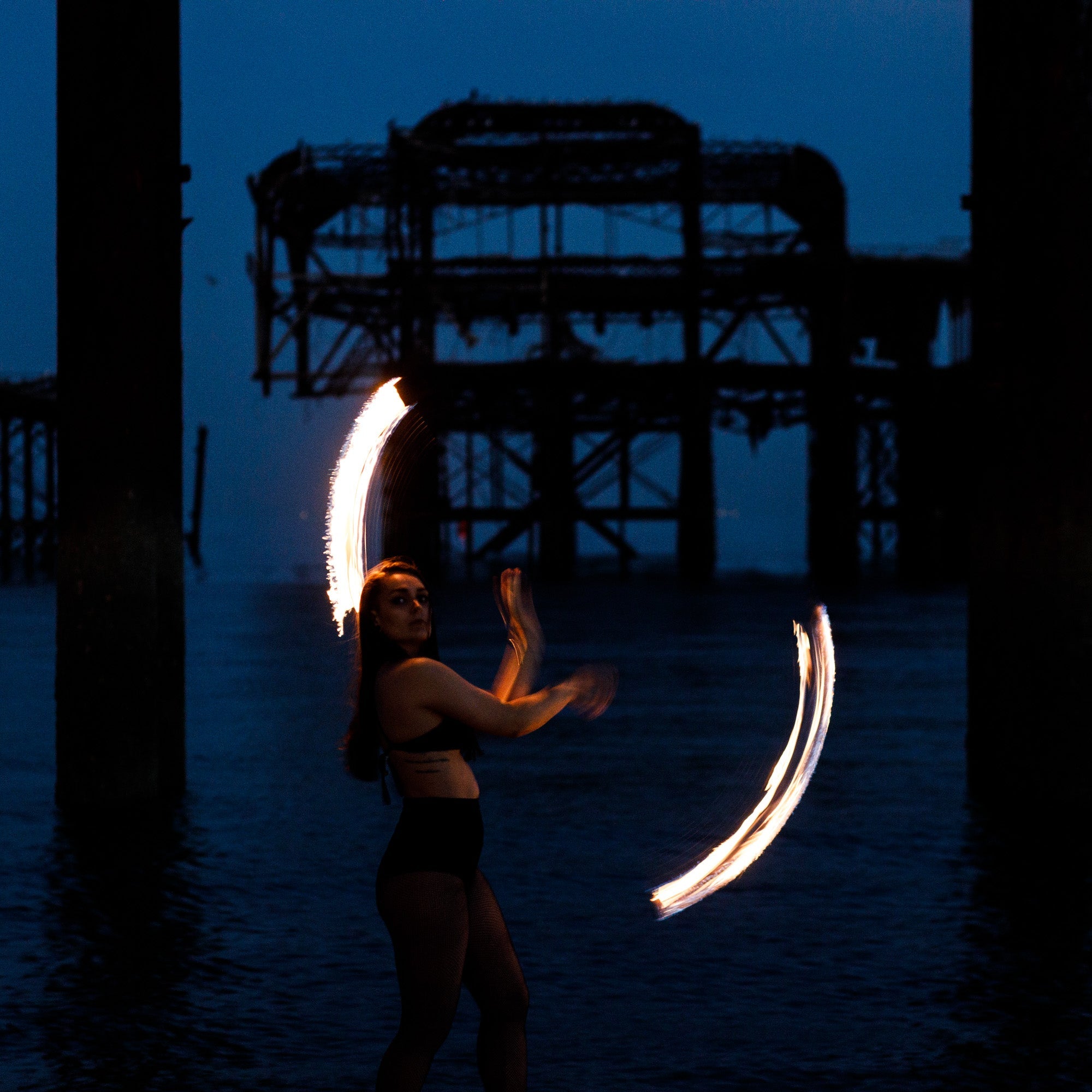 Person spinning fire poi at night