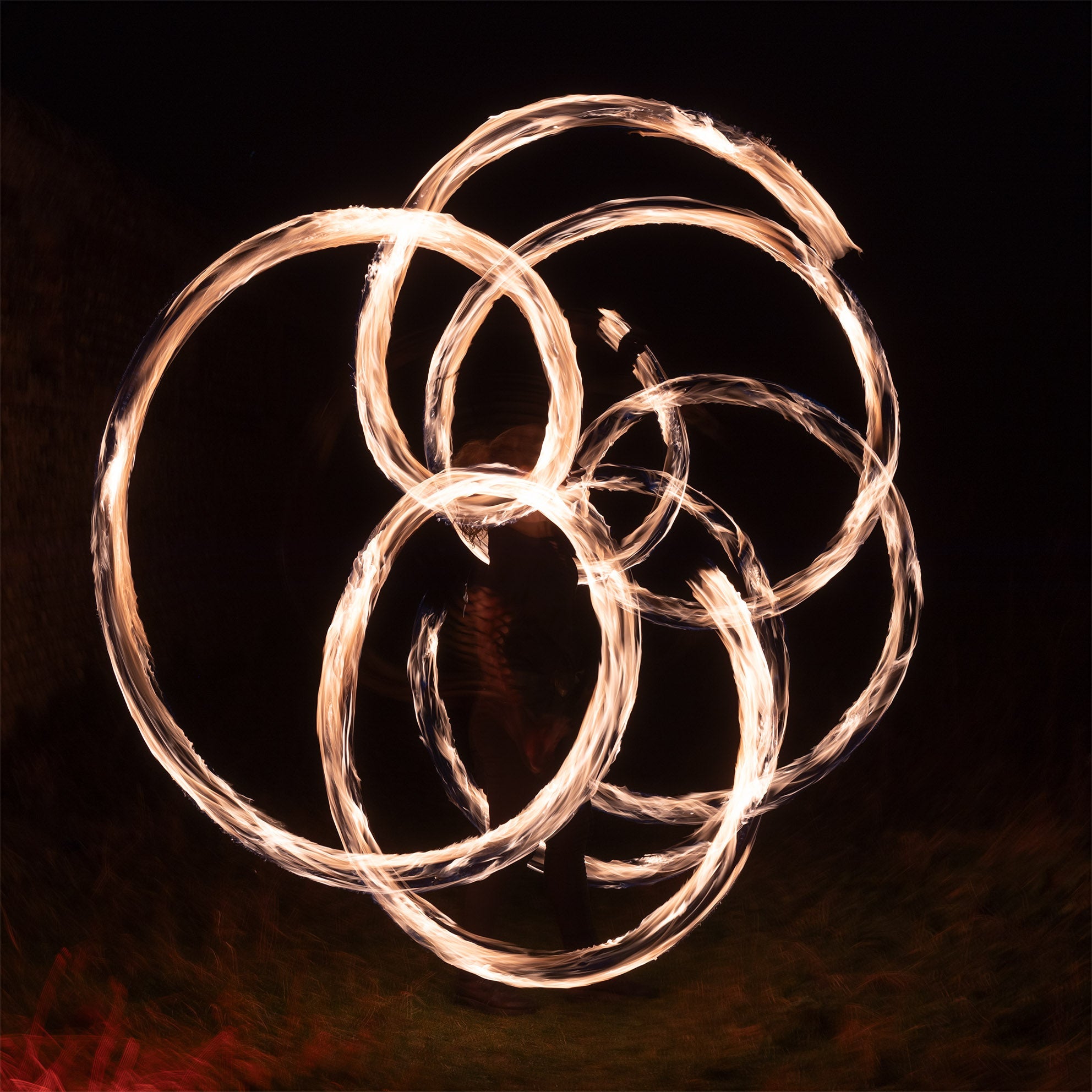 a complex pattern being spun using cathedral fire poi